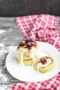 Cottage cheese pancakes with strawberry jam on white plate on grey wooden background. Healthy breakfast Royalty Free Stock Photo