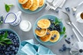 Cottage cheese pancakes, sweet curd fritters with berries, syrniki with honey and fresh blueberry on breakfast table Royalty Free Stock Photo