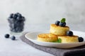 Cottage cheese pancakes, syrniki, curd fritters with fresh blueberries on light background. Russian breakfast menu