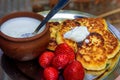 Cottage cheese pancakes/syrniki/curd fritters with fresh strawberries and cream. Traditional Ukrainian and Russian breakfast Royalty Free Stock Photo