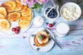 Cottage cheese pancakes syrniki. Homemade cheesecakes from cottage cheese with sour cream, berries and milk.