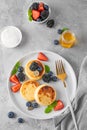 Cottage cheese pancakes, syrniki, ricotta fritters with fresh berries, honey and sour cream on a gray concrete background. Healthy Royalty Free Stock Photo