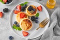 Cottage cheese pancakes, syrniki, ricotta fritters with fresh berries, honey and sour cream on a gray concrete background. Healthy Royalty Free Stock Photo