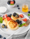 Cottage cheese pancakes, syrniki, ricotta fritters with fresh berries, honey and sour cream on a gray concrete background. Healthy Royalty Free Stock Photo