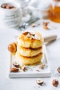 Cottage cheese pancakes with tasty honey and mixed nuts. Syrniki, curd fritters on concrete table