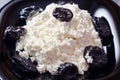 Cottage cheese and prunes on a black plate