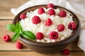 Cottage cheese with raspberry and mint in ceramic bowl on rustic wooden table Royalty Free Stock Photo