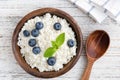 Cottage cheese, ricotta or tvorog with blueberries in wooden bowl