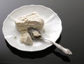 Cottage cheese on a saucer on a black background Royalty Free Stock Photo