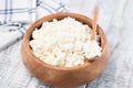 Cottage cheese or tvorog in wooden bowl on white background