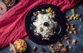 Cottage cheese with walnuts and prunes on a plate. View from above