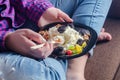 Cottage cheese with walnuts and prunes on a plate. View from above. The girl is eating