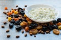 Cottage cheese in white dish. Prunes, dried apricots, dried mandarins and almonds on a light wooden background Royalty Free Stock Photo