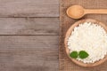 Cottage cheese in a wooden bowl on old wooden background with copy space for your text. Top view Royalty Free Stock Photo