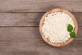 Cottage cheese in a wooden bowl on old wooden background with copy space for your text. Top view Royalty Free Stock Photo