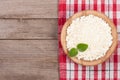 Cottage cheese in a wooden bowl on old wooden background with copy space for your text. Top view Royalty Free Stock Photo