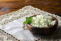 Cottage cheese in a wooden bowl on old wooden background with copy space for your text. Top view Royalty Free Stock Photo