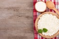 Cottage cheese in a wooden bowl with sour cream on old wooden background with copy space for your text. Top view Royalty Free Stock Photo
