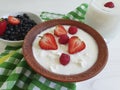 Cottage dairy cheese, yoghurt, strawberry,nutrition dessert lunch blueberries healthy traditional eating a white wooden background Royalty Free Stock Photo