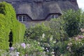 Flowering front garden by a thatched roof cottage Royalty Free Stock Photo