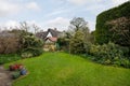 Cottage garden with lawn and high hedge