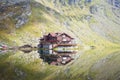 A cottage with reflection in mountain lake Royalty Free Stock Photo