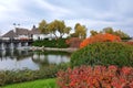 Cottage in rustic style in leaf fall. Rural landscape. Thatched roof house in autumn.Tourism and recreation in countryside Royalty Free Stock Photo