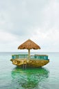 Cottage on top of the rock surrounded with sea water.