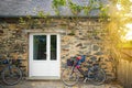 Cottage wall with bycicles at sunset