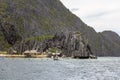 Cottages and boat between karst rocks in philippine sea Royalty Free Stock Photo
