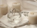 A cotton baptismal shirt for a new born baby, candles and a cross on a coarse string putted into a glass of water Royalty Free Stock Photo