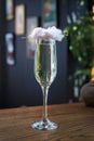 Cotton candy champagne cocktail. Prosecco in a tall flute glass served with a cotton candy cloud, on a wooden table. Royalty Free Stock Photo