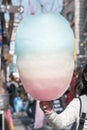 Cotton candy in girl kid`s hand, sugar cloud colorful rainbow color sweet, favorite children`s food in fun fair festival party