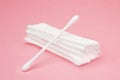 Cotton cosmetic swabs for ear cleaning. Personal care, personal hygiene. Hygienic sanitary swabs on the pink background. Selective