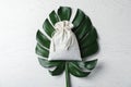 Cotton eco bag and monstera leaf on white table, top view Royalty Free Stock Photo