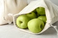 Cotton eco bags with apples on marble table, closeup Royalty Free Stock Photo