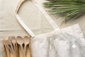 Cotton fabric tote bag wooden flatware cutlery crystal jar bottle green palm leaf on linen background. Plastic-free zero waste Royalty Free Stock Photo