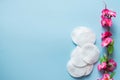 Cotton hygiene products. Cotton pads with pink flowers on blue background top view copy space Royalty Free Stock Photo