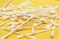 Cotton made ear buds all together close display on yellow background.