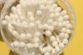 Cotton made ear buds all together close display on yellow background.