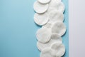 Cotton pads on blue background flat lay.Close-up on group of cotton pads for make up. copy space