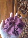 Cotton scrunchie in red with balinese carved wood as background