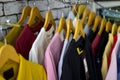 Cotton and sports t-shirts hung on wall hanger racks inside a clothes shop low angle view with the focused depth of field Royalty Free Stock Photo