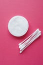 Cotton swabs and disks isolated on a pink background. Hygiene products