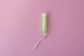 Cotton tampon with light green applicartor on a pink background. Woman days hygiene protection. Menstrual cycle period concept. Royalty Free Stock Photo