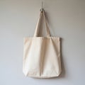 Cotton tote bag hanging on a wall hook. The bag is beige, showcasing a simple and Royalty Free Stock Photo