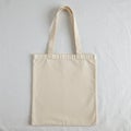 Cotton tote bag on a white background. The bag is rectangular with two handles, Royalty Free Stock Photo