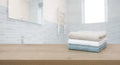Cotton towels on wooden table in blurred bathroom interior background Royalty Free Stock Photo