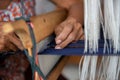 Cotton weaving. Close-up woman hand weaving cotton on manual loom. Thai cotton handmade. Homespun fabric process. The process of