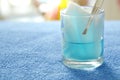 Cotton wool with tweezers picking in blue alcohol on glass Royalty Free Stock Photo